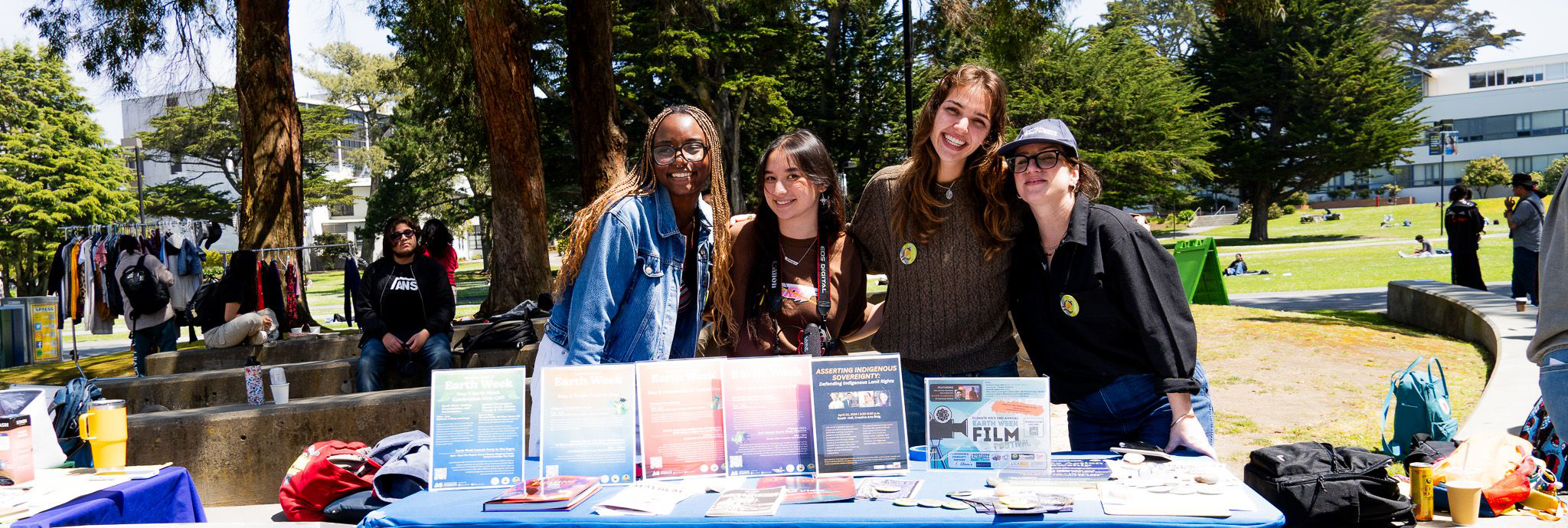 Four students smiling behind a ClimateHQ table.