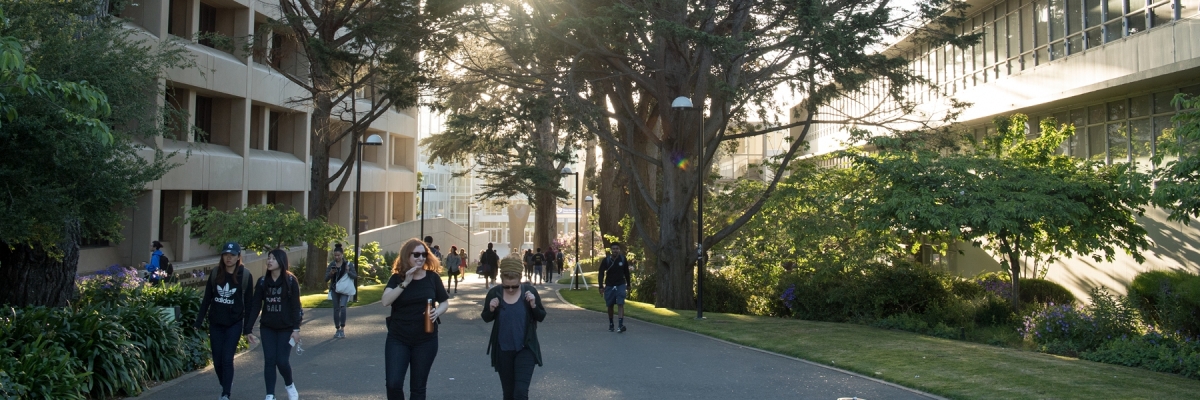 Students walk between the admin and CHSS buildings on a sunny afternoon